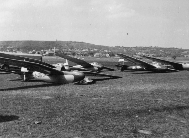 repülőtér, balra Jancsó-Szokolay M-22 vitorlázó repülőgépek, jobbra egy sötét színű Göppingen Gö-4 vitorlázó repülőgép.