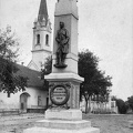 Rákóczi utca, I. világháborús emlékmű (Kallós Endre 1924.). Háttérben a Szent Péter római katolikus templom.
