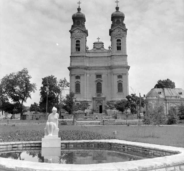 a Szent Kereszt Plébánia előtte a Kossuth téren a Vízbenéző lány szobra.