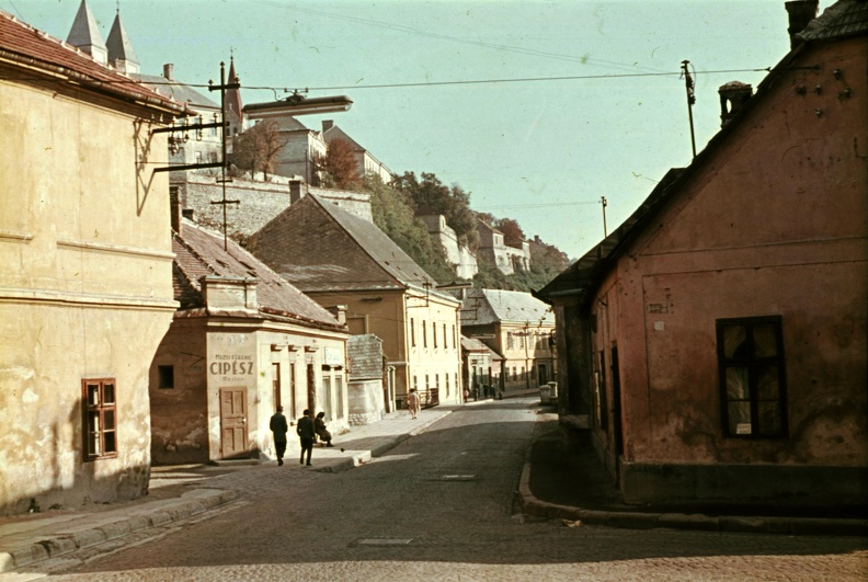 Szent István (Vörös Október) utca - Eszterházy Antal (Szabad nép) utca sarok, szemben a Jókai Mór utca. Balra fenn a Vár.