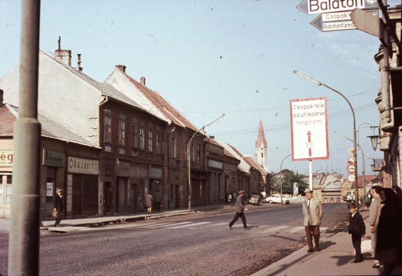 Kossuth Lajos utca (mára lebontott) házsora, háttérben az evangélikus templom.