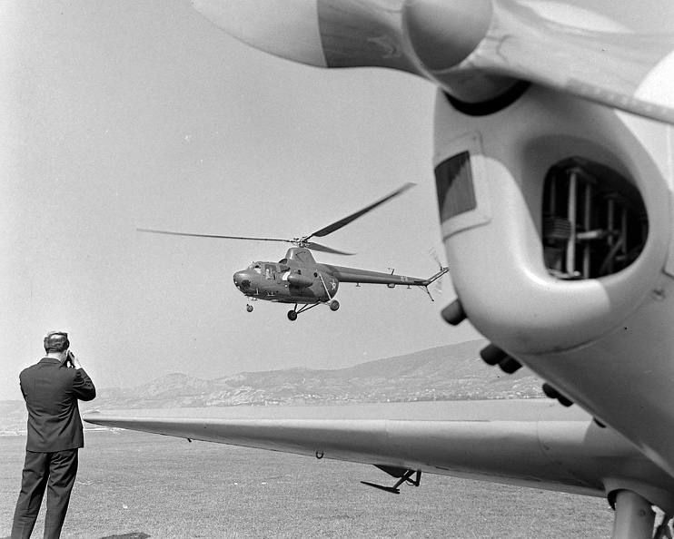 előtérben egy Zlin Trener repülőgép, a háttérben egy Mi-1 típusú katonai helikopter.